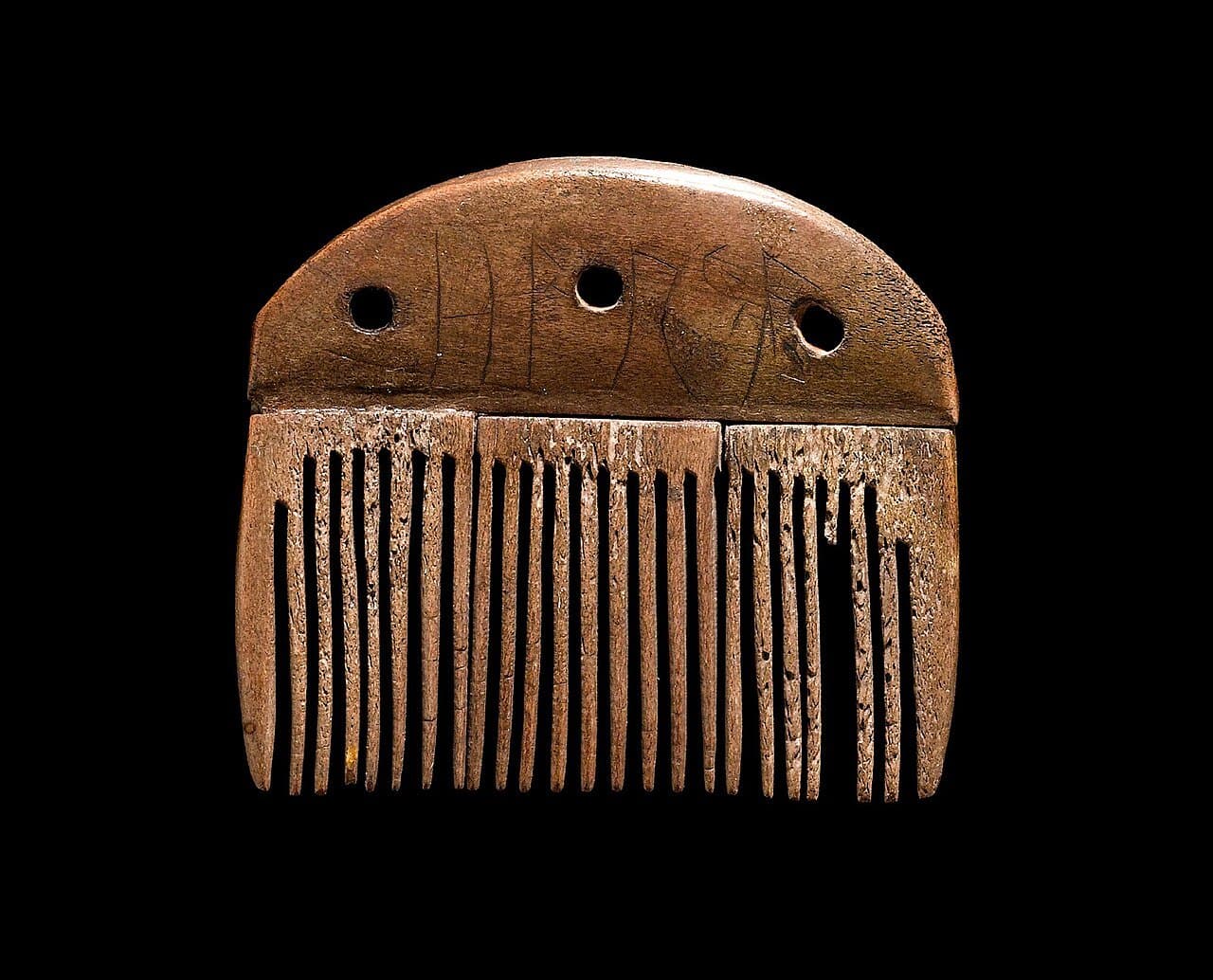 The Vimose comb, made of antler, with a runic inscription cut along its upper edge
