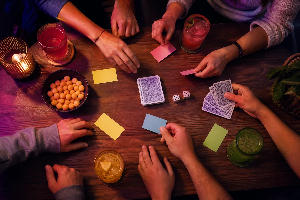 Friends playing cards and dice together around a table